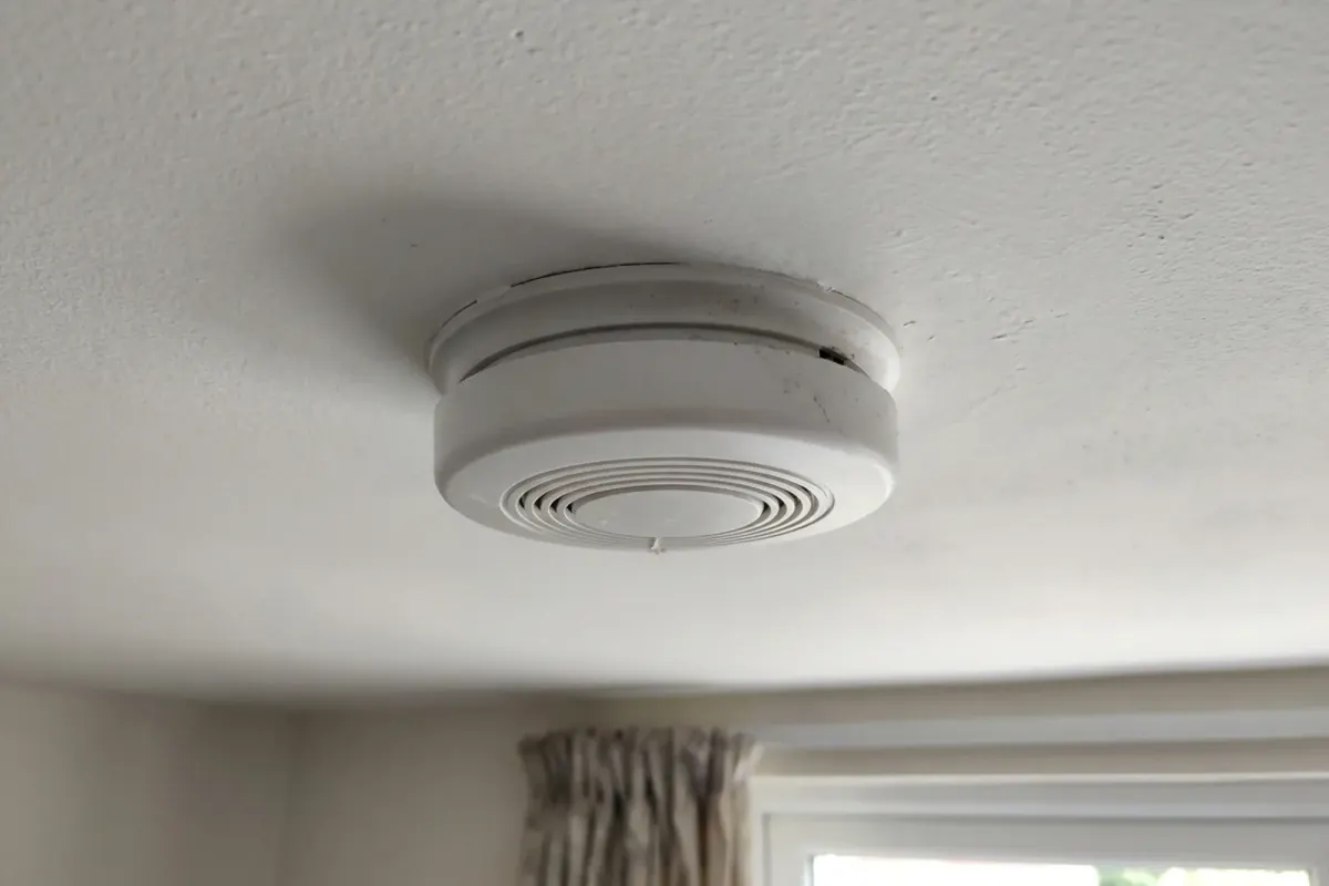 A smoke alarm on a white ceiling